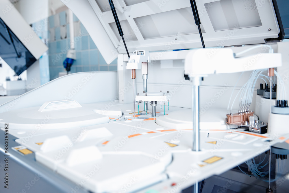 Automatic robot microbiologist analyzing test tube of blood samples for viruses. Concept vaccine search coronavirus 2019-nCoV Automatic robot microbiologist analyzing test tube of blood samples for viruses. Concept vaccine search coronavirus 2019-nCoV