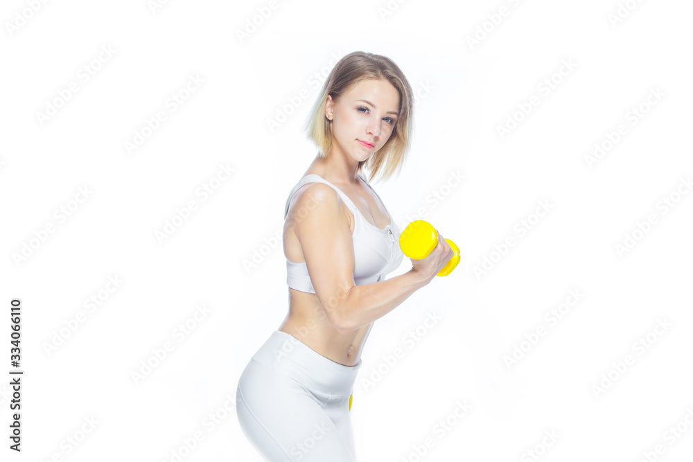 Fitness woman working out with yellow dumbbells showing her muscles on white background Fitness woman working out with yellow dumbbells showing her muscles on white background