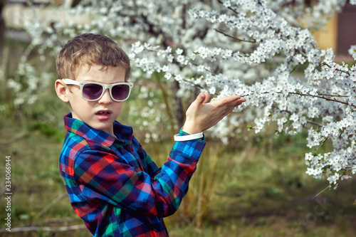 Portrait of a boy at a flowering tree . Children on a walk on a spring day .Walking in the fresh air