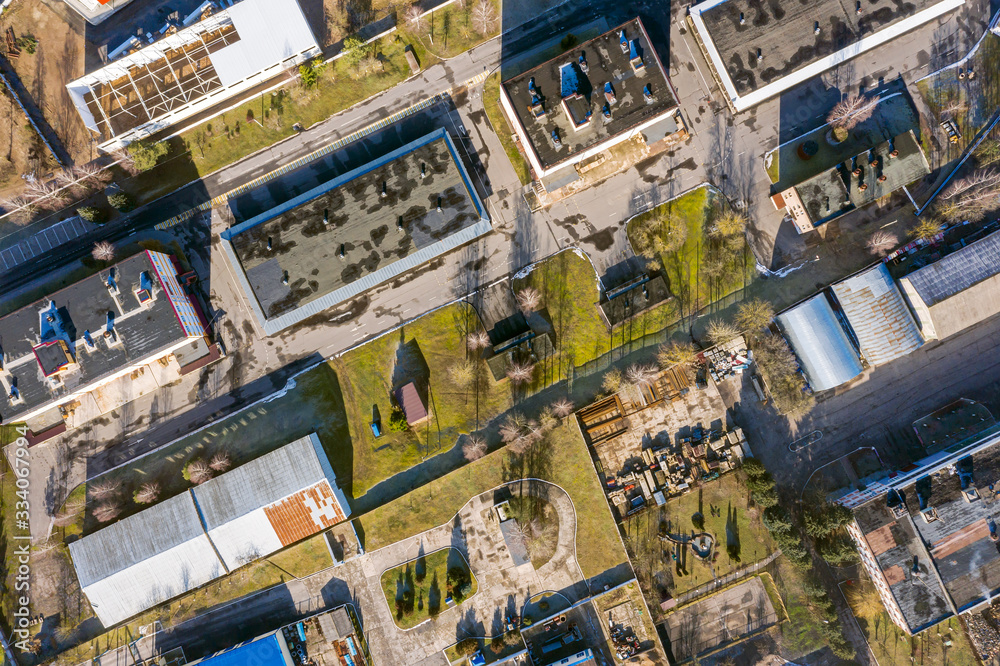 Fototapeta premium aerial view of suburb industrial area with group of modern warehouses, factory buildings and distributions centers. industrial district background