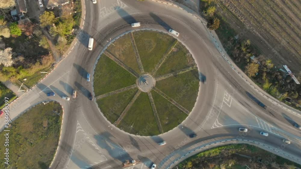 Aerial view of a traffic road circle in time lapse 4K video. Transpotation and city scene. Aerial view of a traffic road circle in time lapse 4K video. Transpotation and city scene.
