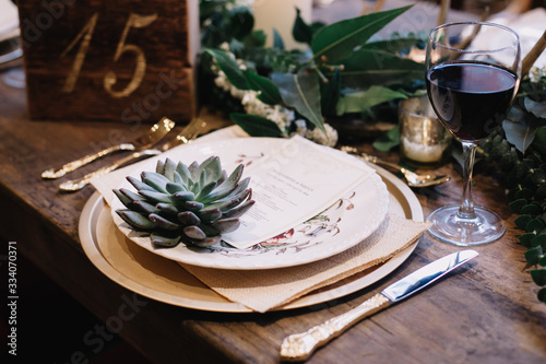 A table scape designed for a boho style event with an eucalyptus garland and succulents, vintage plates and other rustic touches