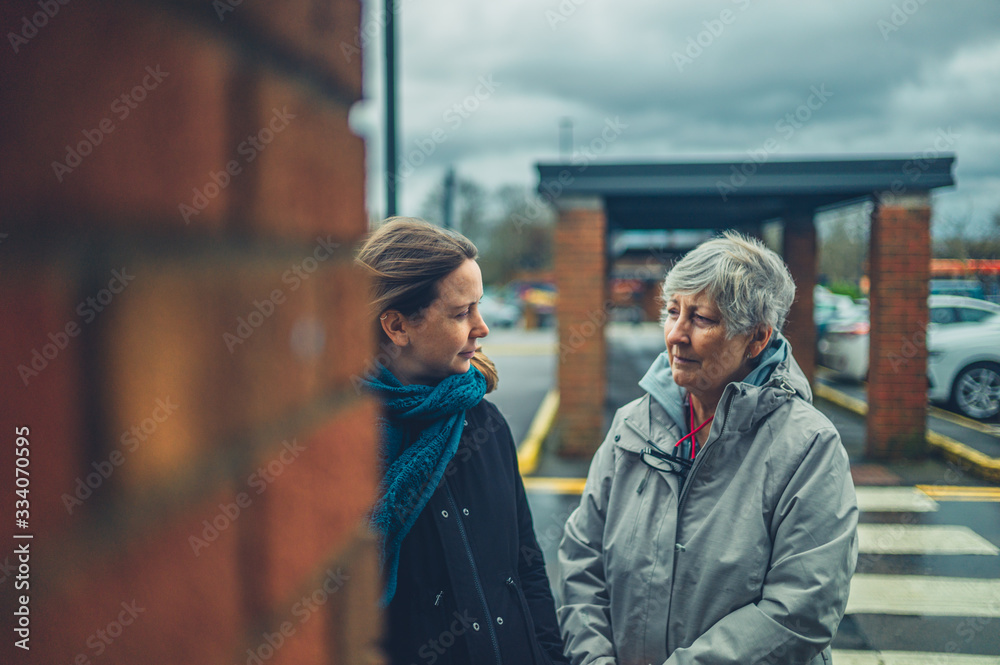 Young woman talking to her mother in a parking lot