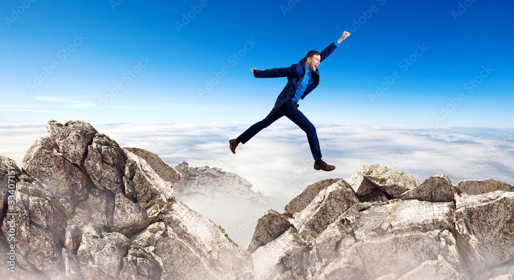 Young businessman flying through the gap among mountains. Young businessman flying through the gap among mountains.