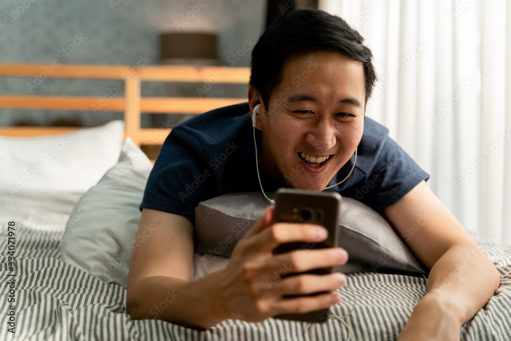 © twinsterphoto - Portrait of happy 30s aged Asian man in casual clothing making facetime video calling with smartphone at home. Using conferencing meeting online app, social distancing, work from home concept © twinsterphoto - Portrait of happy 30s aged Asian man in casual clothing making facetime video calling with smartphone at home. Using conferencing meeting online app, social distancing, work from home concept