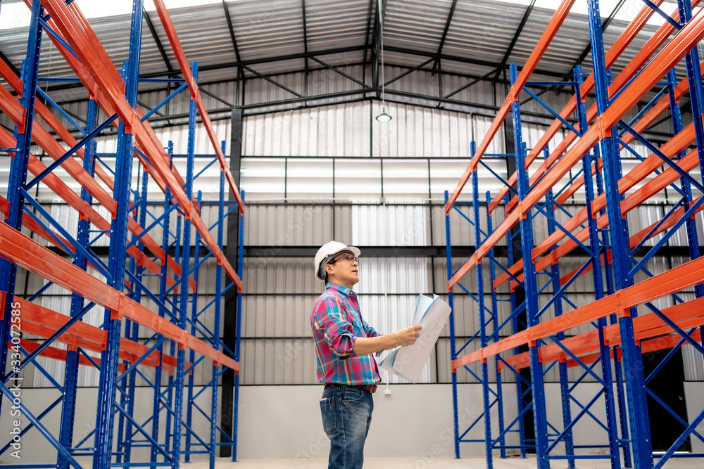 Engineer Man Worker Wearing Safety Helmet checking Interior of Distribution Warehouse.