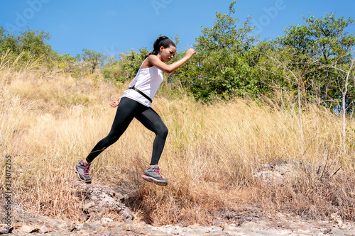 Young Black Woman Running and Jumping at Forest Trail.