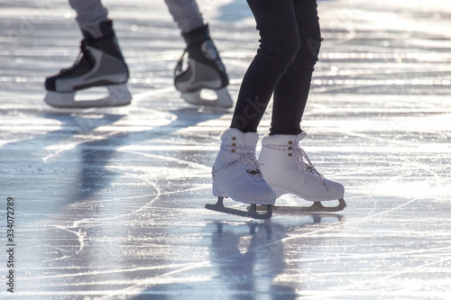 feet of different people skating on the ice rink © photosaint