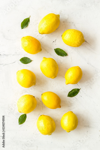 Lemons backgrond - whole fruits with leaves - on white table top-down