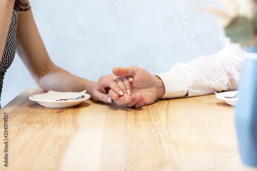 Cropped image of happy young couple holding hands
