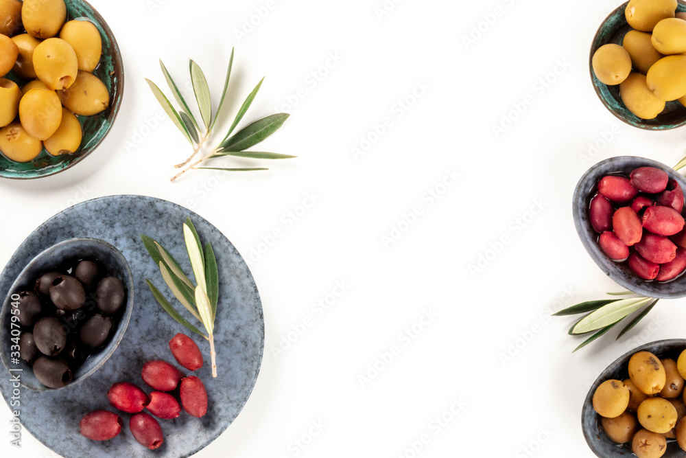 Olives background with a place for text. A flat lay of green, black and red olives, shot from the top on white