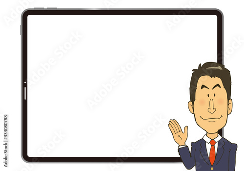 大きなタブレットの画面を背に説明をしているスーツの男性