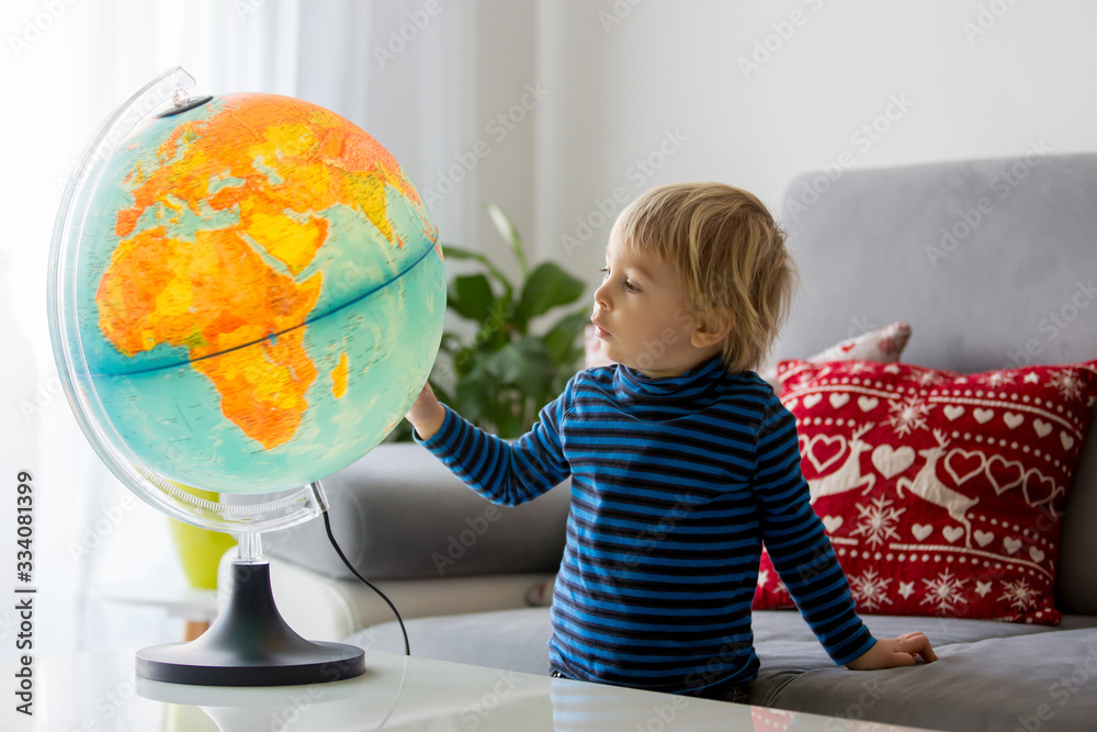 Little child, looking at illuminated globe, exploring Little child, looking at illuminated globe, exploring