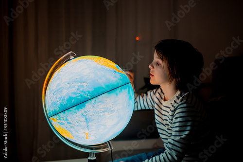 Little child  looking at illuminated globe  exploring