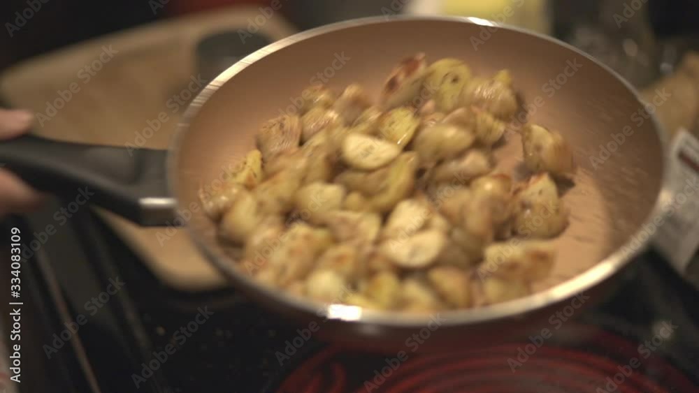 The Gentle Shaking Of The Pan With Potatoes Cut In Wedges While Cooking. -close up shot The Gentle Shaking Of The Pan With Potatoes Cut In Wedges While Cooking. -close up shot