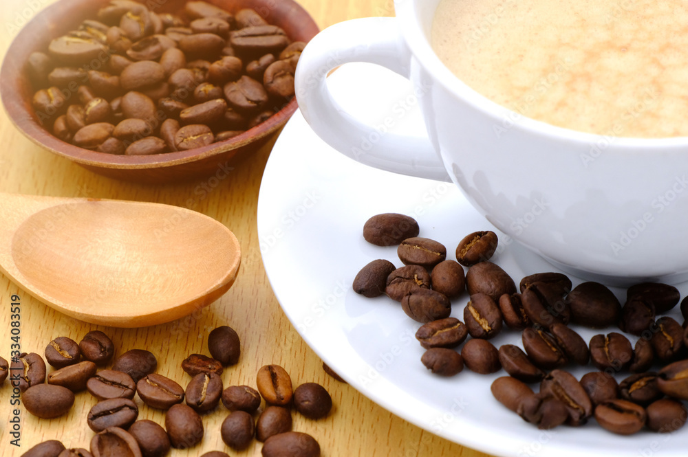 Coffee cup and beans on wooden kitchen table. Top view with morning sunlight Coffee cup and beans on wooden kitchen table. Top view with morning sunlight