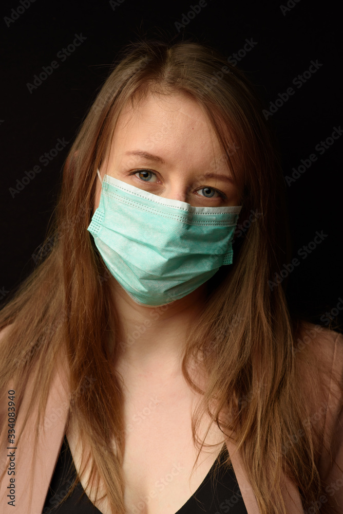 Young girl in a medical mask on a black background. Young girl in a medical mask on a black background.