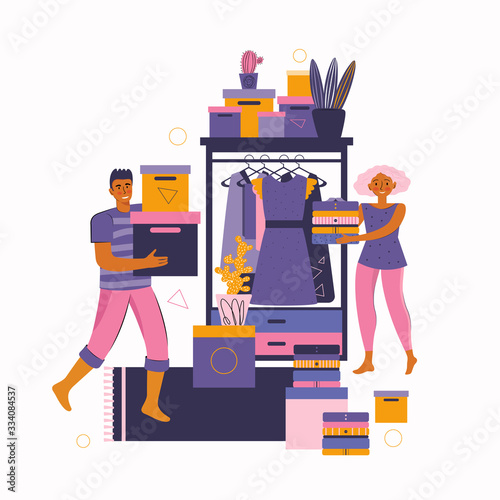 Man and a woman spend time together at home. Young couple doing housework and fold clothes in the wardrobe. Cleaning the room. Inner space of closet. Stay at home together. Spending time at home