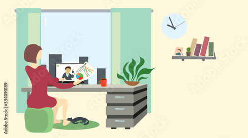 woman in red dress at table table is negotiating a video call via laptop from home. time to work comfortably from home