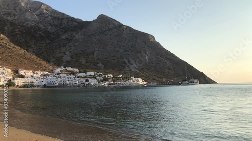Kamares village and sandy beach at sunset, in Sifnos island in Greece, with many tourists. photo