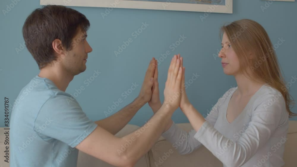 Portrait of beautiful family indoors. Husband helping his wife to relax. Couple relaxing exercise. Man and woman holding hands, woman doing breathing exercises Portrait of beautiful family indoors. Husband helping his wife to relax. Couple relaxing exercise. Man and woman holding hands, woman doing breathing exercises