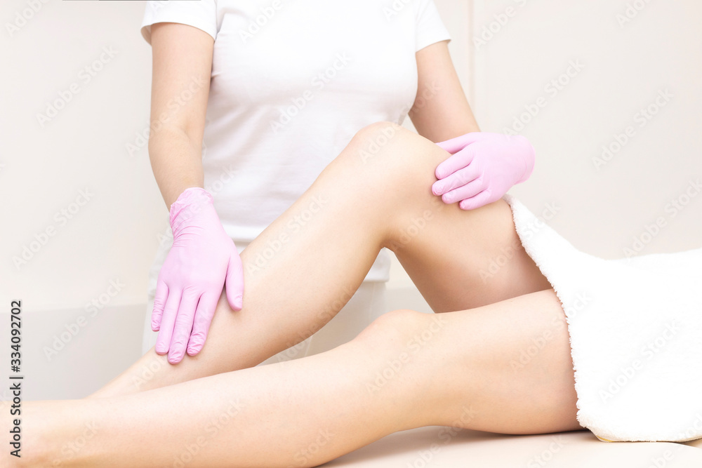 depilation and massage. Beautiful female legs with smooth skin. depilation master, masseur with gloves. depilation and massage. Beautiful female legs with smooth skin. depilation master, masseur with gloves.