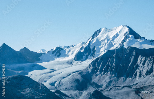 Mountain top view panorama. Lovely scenery landscape with blue sky, snow peaks, high rocks and glacier.