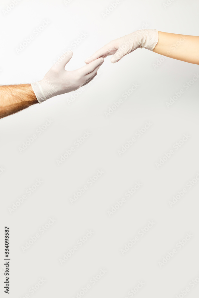 Male and female hand in medical gloves holding each other. Male and female hand in medical gloves holding each other.