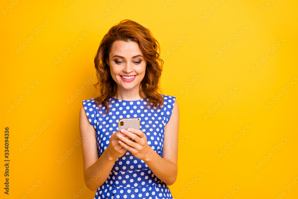 Portrait of her she nice attractive lovely pretty focused cheerful cheery wavy-haired girl using internet online web service isolated on bright vivid shine vibrant yellow color background