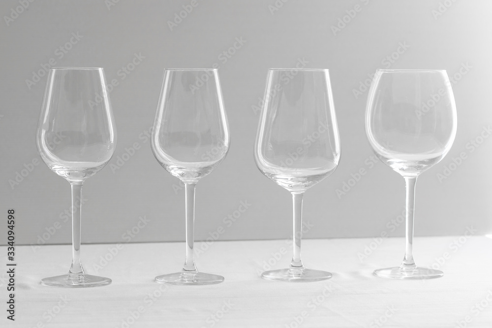 Fototapeta premium Several empty wine glasses for red, rose, white and bordeaux in white grey shades