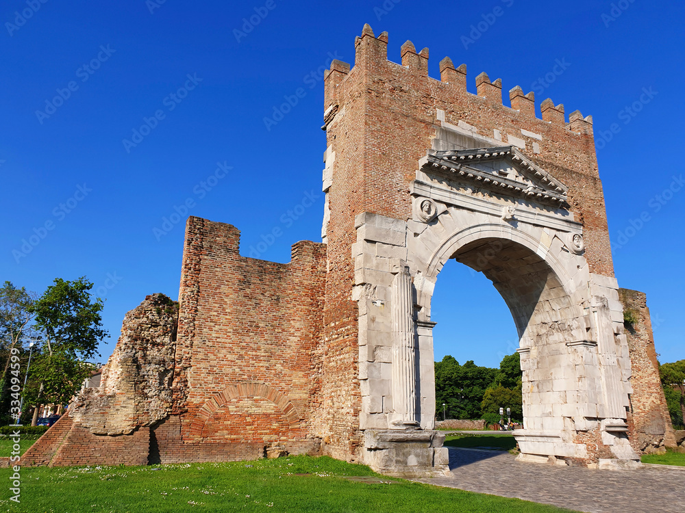 The Augustus arch is the main attraction of the city of Rimini. Triumphal arch of Rimini on a sunny summer day.