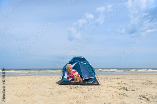 Man with dog camping in shelter at the beach