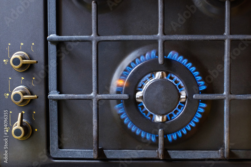 Gas burner on black modern kitchen stove. kitchen gas cooker with burning fire propane gas.