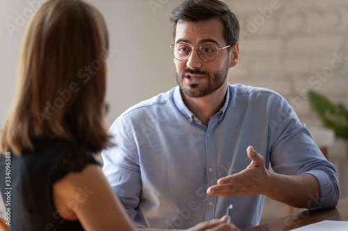 Canvas Print Caucasian male applicant answers on questions to HR female manager during job interview in office