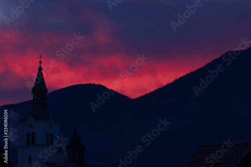 Pink sunlit sky over church in Bohinjska Bistrica