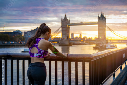 Fitness in der Stadt: Weibliche Läuferin erholt sich von ihrem morgendlichen Training vor der Tower Brücke in London photo