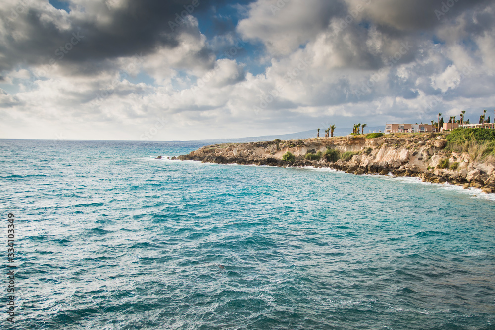 Cyprus coastline. Landscape of a Mediterranean rocky seashore before the storm below the stormy clouds.