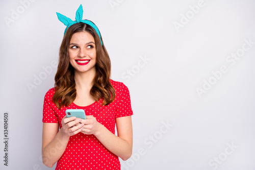 Portrait of positive cheerful girl use smart phone want type social network news look copyspace dream dreamy wear stylish trendy blue outfit isolated over grey color background