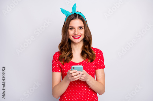 Portrait of positive cheerful blogger redhead girl use cellphone enjoy texting typing sms wear stylish vintage style outfit isolated over grey color background