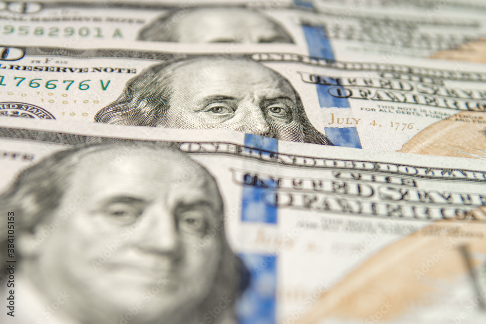 United States dollars. Pile of hundred USD banknotes. Photo with selective focus