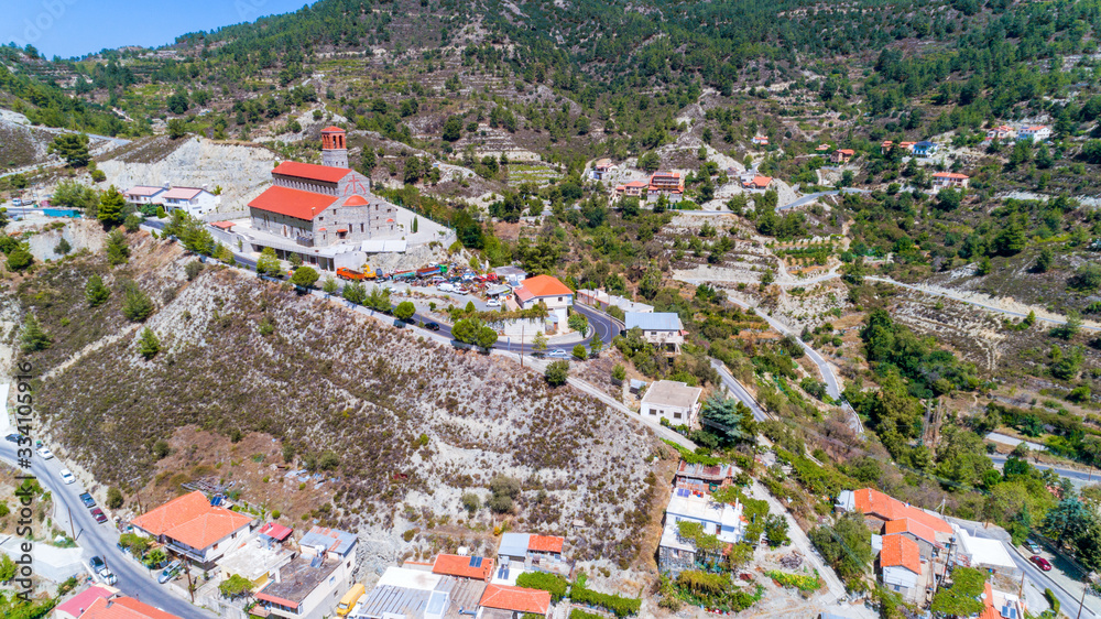 Aerial view of Agios Arsenios church, Kyperounda village, Limassol, Cyprus. Traditional landmark christian greek orthodox, ceramic tiled roof, stone bell tower architecture in Kyperounta from above