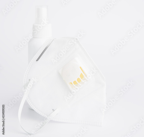 White mask for wearing germ protection  and gel alcohol or hand sanitizer spray bottle for washing hand  to protect from corona cirus set on white background photo