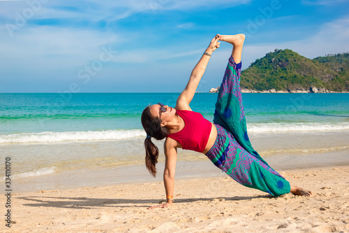 Asian Thai woman practicing yoga in Ao Thong Nai Pan Noi beach, Koh Phangan island, Thailand photo