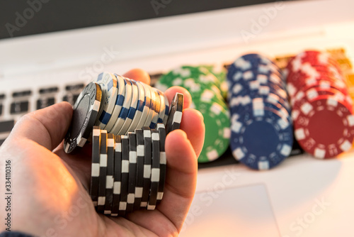 Different of cost casino chips stacking on a laptop. Gabmling