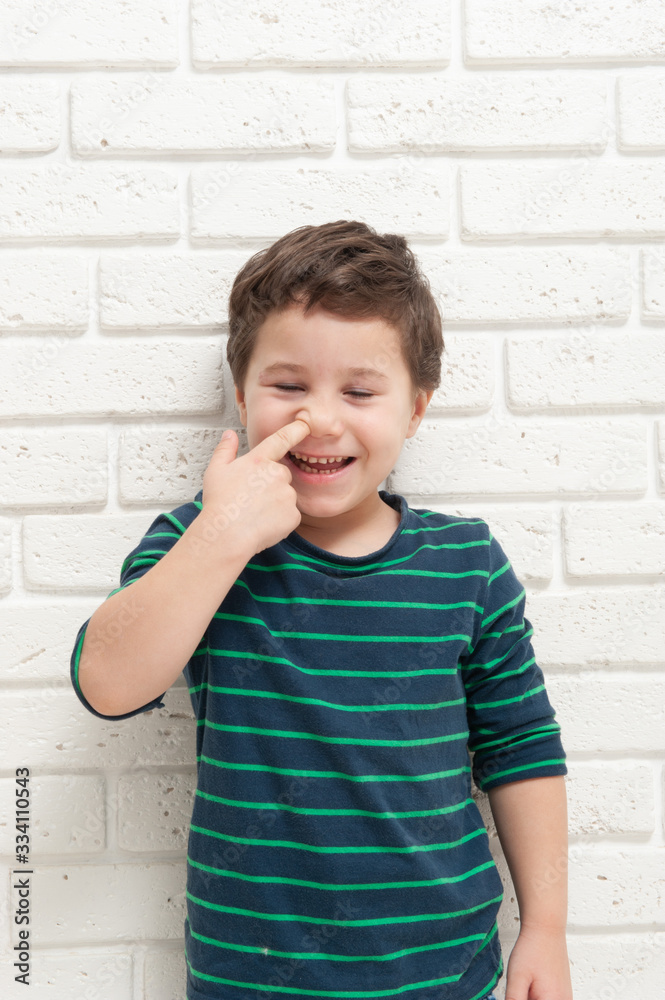 Little boy picks his nose with his finger Little boy picks his nose with his finger