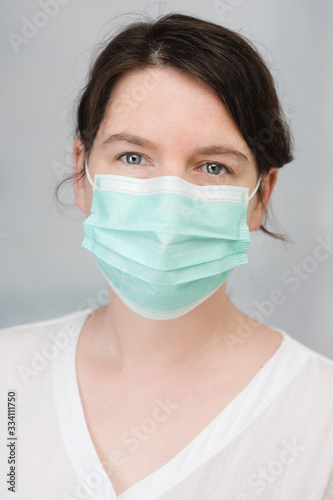 junge Frau mit medizinischem Mundschutz als Schutz vor Viren und Bakterien Covid-19 Coronavirus Maßnahmen Krankenschwester medizinisches Personal