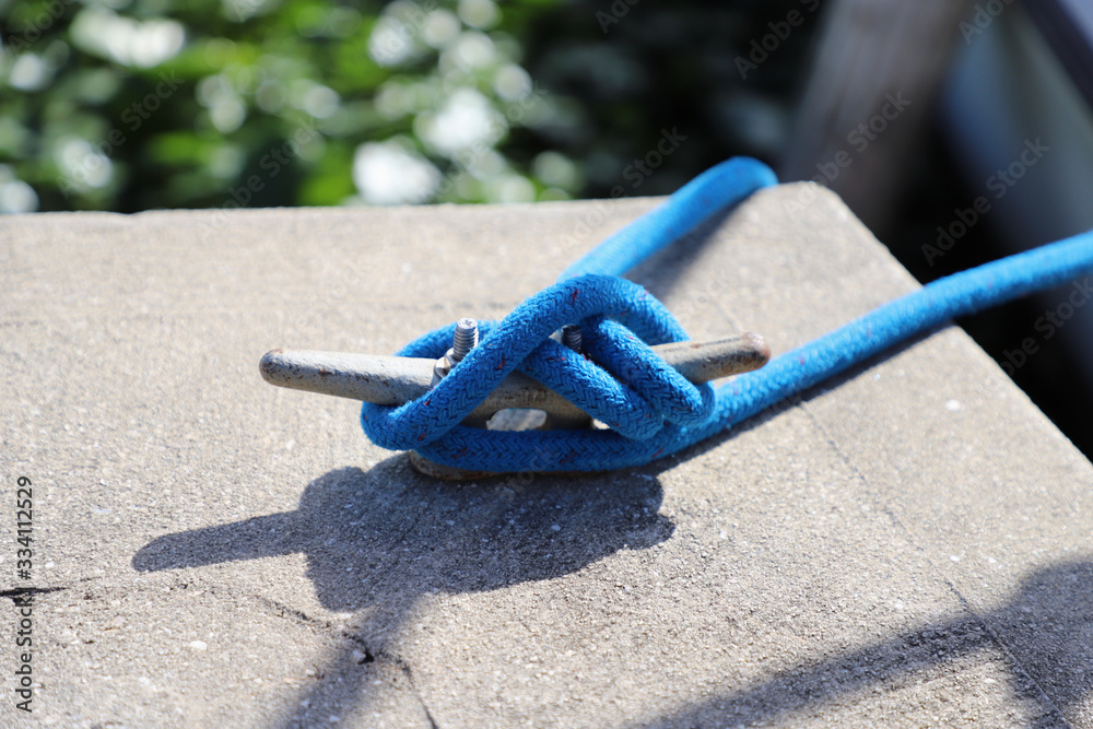 Blue rope tied around metal anchor point