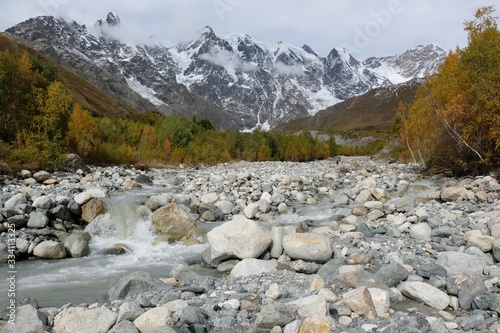 Riverbed Khaldechala with a lot of stones. Snowy peaks Dzhangi-Tau and Shkhara with Khalde Glacier in background. Greater Causasus, Svaneti, Georgia