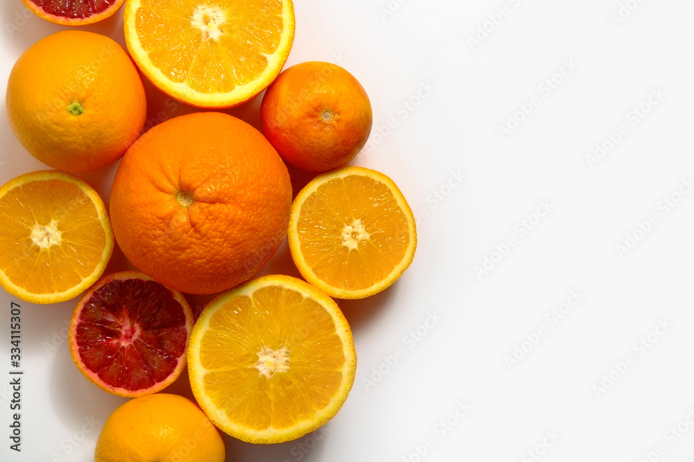 Close up image of juicy organic whole and halved assorted citrus fruits with visible core texture, isolated white background, copy space. Vitamin C loaded food concept. Top view, flat lay. Close up image of juicy organic whole and halved assorted citrus fruits with visible core texture, isolated white background, copy space. Vitamin C loaded food concept. Top view, flat lay.