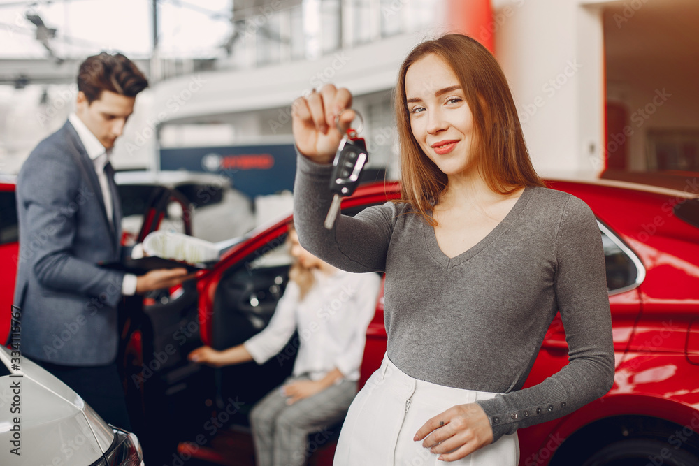 Woman buying the car. Lady in a car salon. Manager with a clients Woman buying the car. Lady in a car salon. Manager with a clients